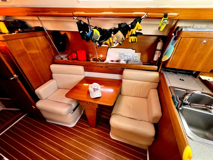 Alcyone Yacht Photos Pics Interior of 2007 Catalina 350 sailboat with cozy seating and wooden finishes.