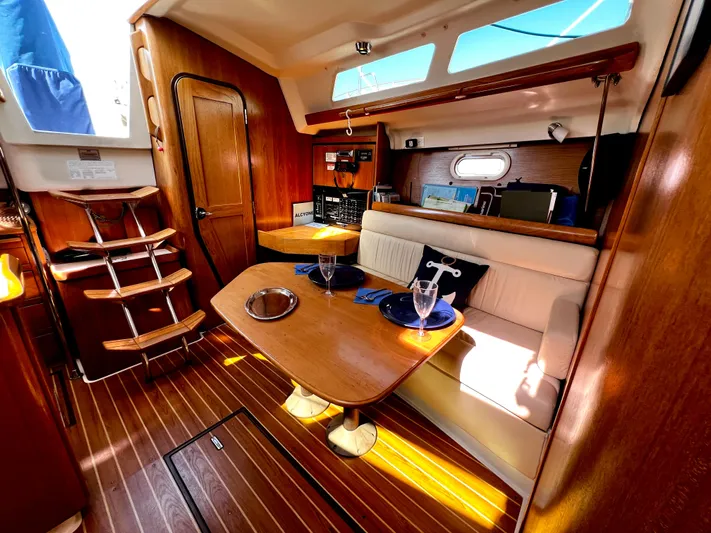 Alcyone Yacht Photos Pics Interior of a 2007 Catalina 350 sailboat with wooden finishes and cozy seating area.
