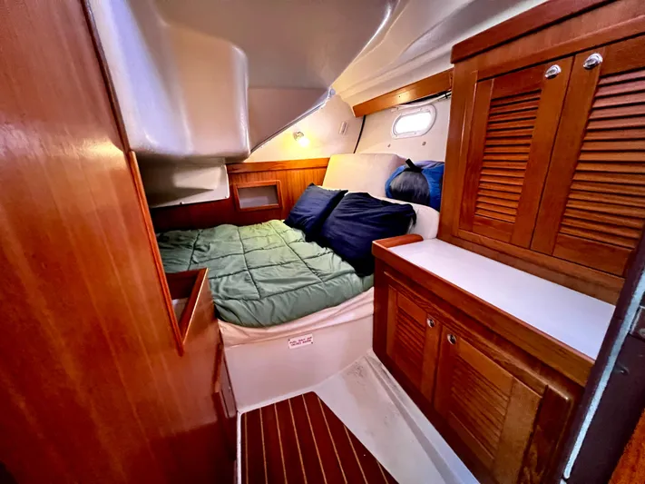 Alcyone Yacht Photos Pics Cozy cabin interior of a 2007 Catalina 350 sailboat with wooden cabinetry and a comfortable bed.
