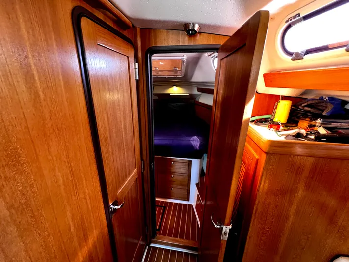 Alcyone Yacht Photos Pics Interior of a 2007 Catalina 350 sailboat with wooden cabinetry and cozy sleeping quarters.