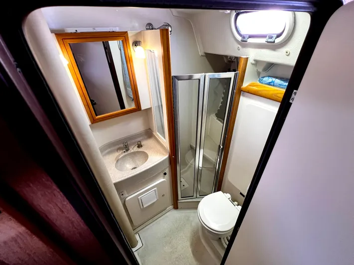 Alcyone Yacht Photos Pics Compact bathroom in a 2007 Catalina 350 sailboat with sink, mirror, and toilet.