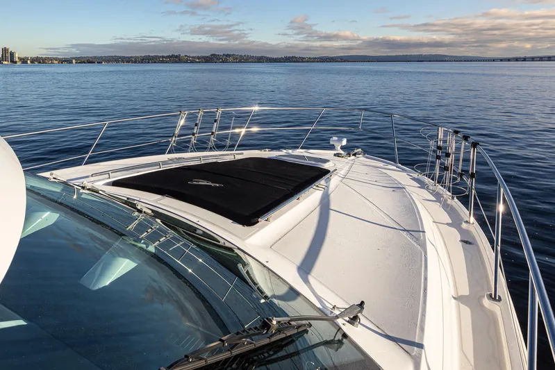  Yacht Photos Pics 2010 Sea Ray Sundancer yacht on calm water with clear sky and distant shoreline.