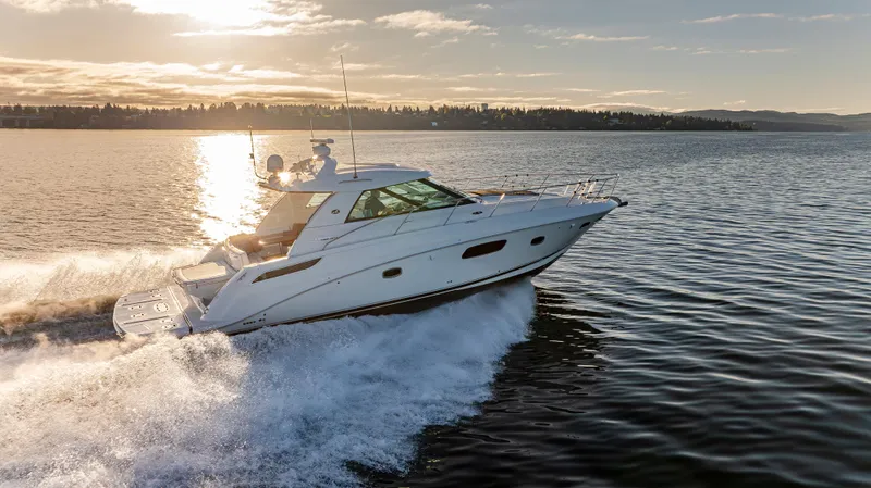  Yacht Photos Pics 2010 Sea Ray Sundancer cruising on a sunlit lake at sunset.