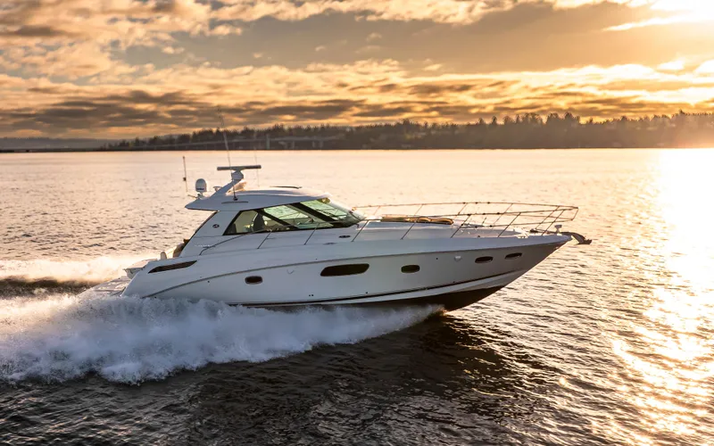  Yacht Photos Pics 2010 Sea Ray Sundancer cruising on a serene lake at sunset.