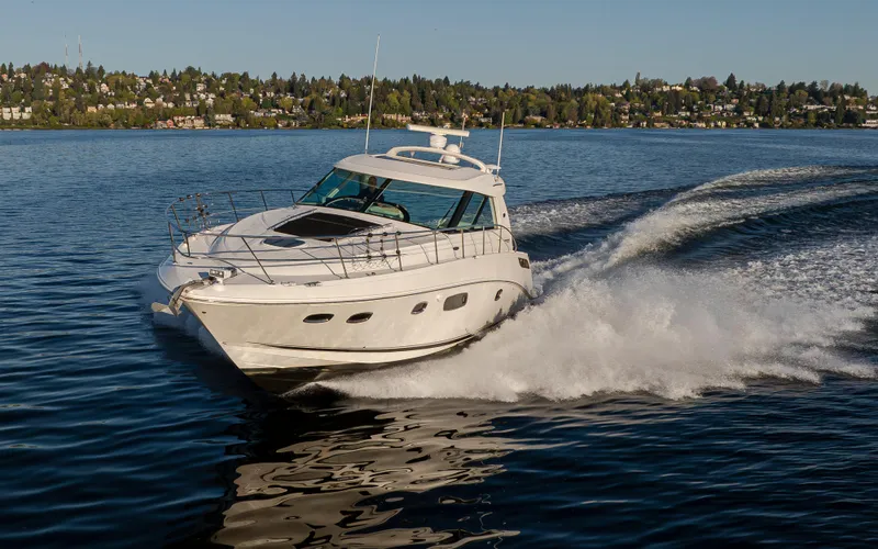  Yacht Photos Pics 2010 Sea Ray Sundancer cruising on a serene lake with scenic shoreline.