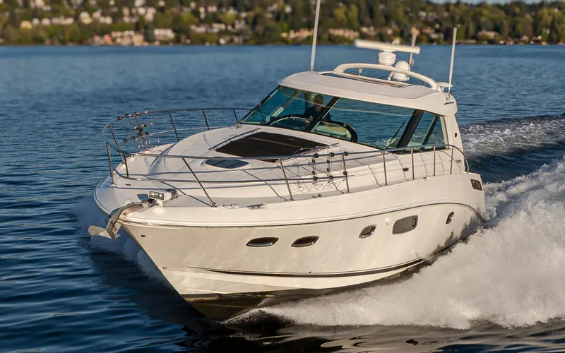  Yacht Photos Pics 2010 Sea Ray Sundancer cruising on a serene lake with lush green shoreline.