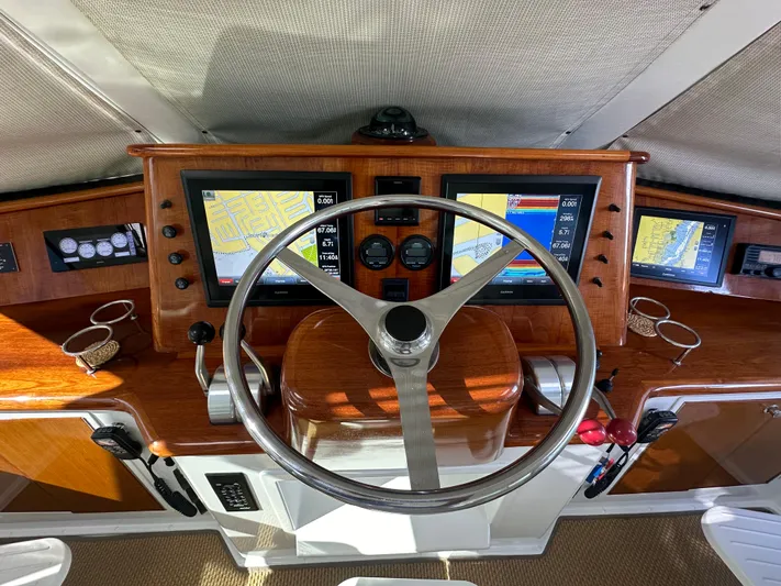 Bebe Yacht Photos Pics Cockpit of 1999 Viking 60 Sports Yacht with navigation screens and wooden steering wheel.
