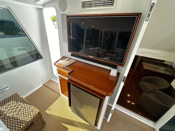 Bebe Yacht Photos Pics 1999 Viking 60 Cockpit Sports Yacht interior with TV, mini-fridge, and wooden cabinetry.