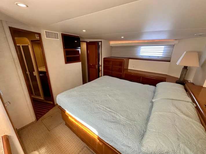 Bebe Yacht Photos Pics Luxurious bedroom interior of 1999 Viking 60 Cockpit Sports Yacht with cozy bed and wooden furnishings.