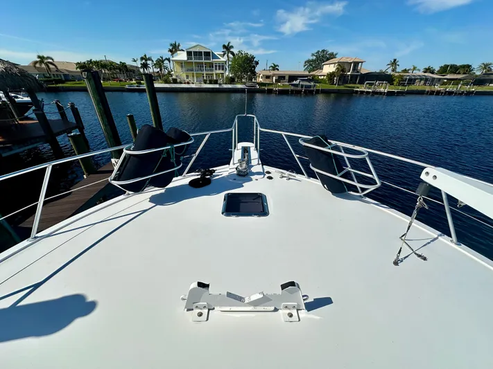 Bebe Yacht Photos Pics Bow view of 1999 Viking 60 Cockpit Sports Yacht docked by waterfront homes.