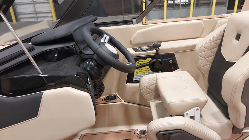  Yacht Photos Pics 2025 Nautique GS24 boat interior with beige leather seats and modern steering console.