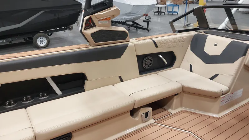  Yacht Photos Pics 2025 Nautique GS24 boat interior with beige and black seating, cup holders, and modern design.