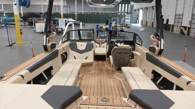  Yacht Photos Pics 2025 Nautique GS24 boat interior with luxurious seating and modern design in a spacious warehouse.