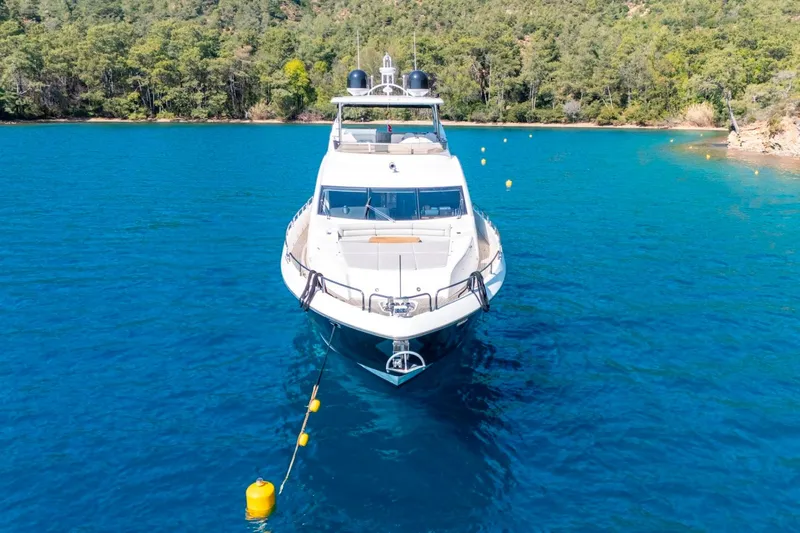  Yacht Photos Pics Front view of a 2011 Sunseeker 80 Yacht anchored in clear blue water.