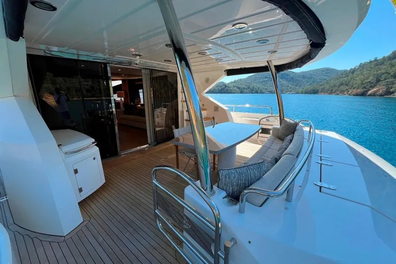  Yacht Photos Pics Luxurious 2011 Sunseeker 80 Yacht deck with seating, overlooking serene blue waters and lush hills.