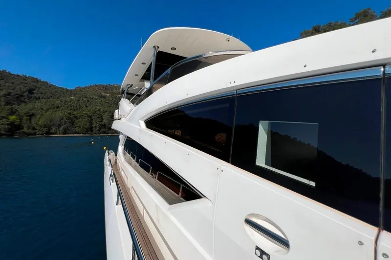  Yacht Photos Pics Sunseeker 80 Yacht 2011 cruising on serene blue waters near lush green hills.