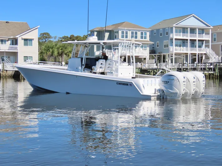  Yacht Photos Pics 2024 Contender 39ST boat on calm water near waterfront homes.