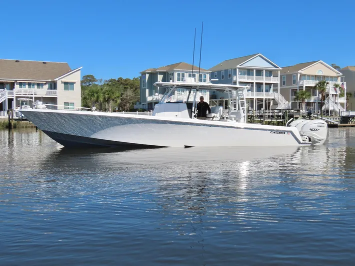  Yacht Photos Pics 2024 Contender 39ST boat on calm water near waterfront homes.