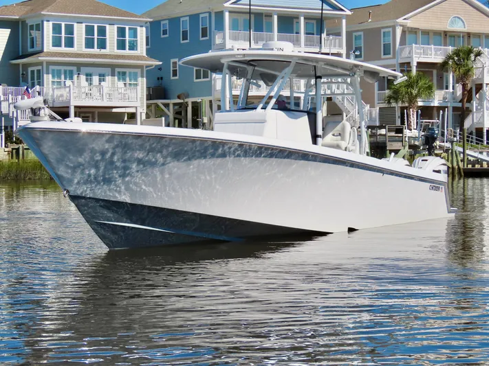  Yacht Photos Pics 2024 Contender 39ST boat on calm water near waterfront homes.