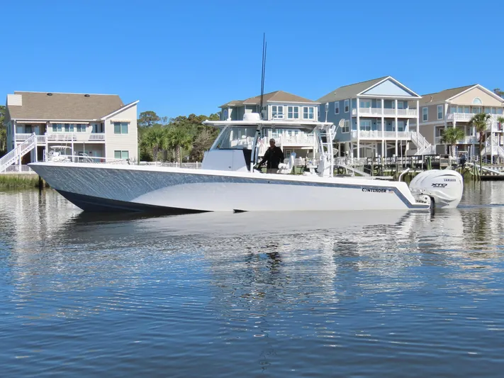  Yacht Photos Pics 2024 Contender 39ST boat on calm water near waterfront homes.