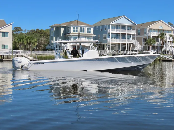  Yacht Photos Pics 2024 Contender 39ST boat cruising near waterfront homes.