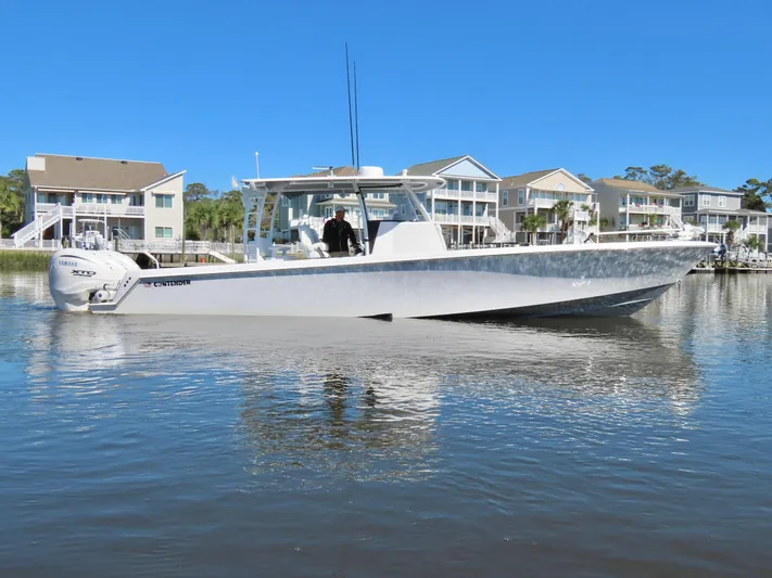  Yacht Photos Pics 2024 Contender 39ST boat on calm water near waterfront homes.