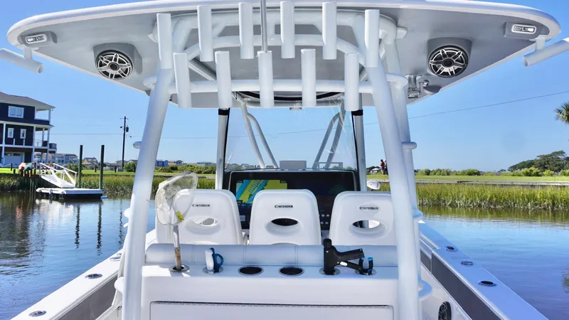  Yacht Photos Pics 2024 Contender 39ST boat with sleek design, docked near waterfront homes.