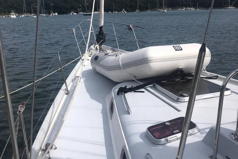 Tumblehome Yacht Photos Pics 1995 Little Harbor 51 Pilothouse yacht deck with inflatable dinghy on calm water.