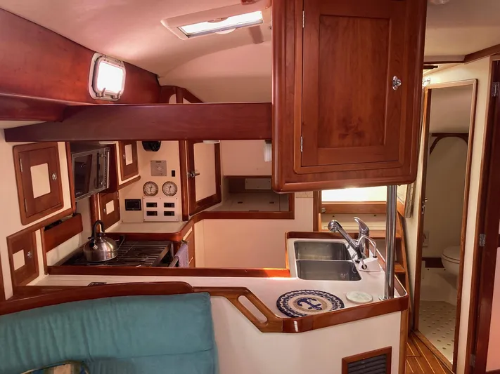 Tumblehome Yacht Photos Pics Interior of 1995 Little Harbor 51 Pilothouse yacht, featuring a compact kitchen and wooden cabinetry.