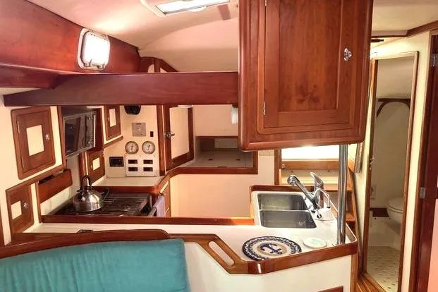 Tumblehome Yacht Photos Pics Interior of 1995 Little Harbor 51 Pilothouse yacht, featuring a compact kitchen and wooden cabinetry.