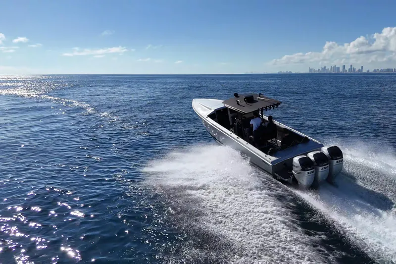  Yacht Photos Pics High-speed Lazer 40 boat cruising on open sea, 2006 model, with city skyline in background.