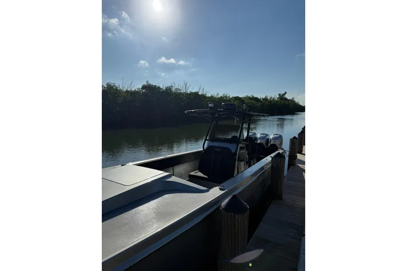  Yacht Photos Pics 2006 Lazer 40 boat docked by a serene river under a bright sky.