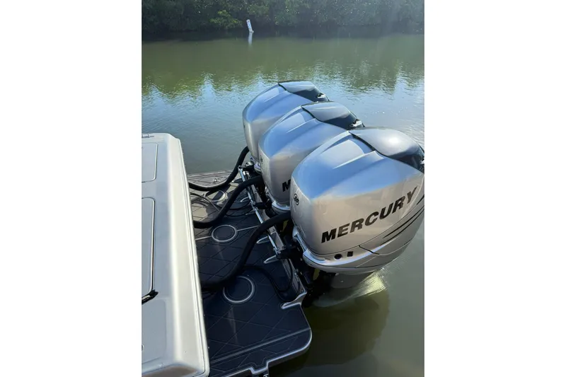  Yacht Photos Pics Triple Mercury outboard engines on a 2006 Lazer 40 boat, docked on calm water.