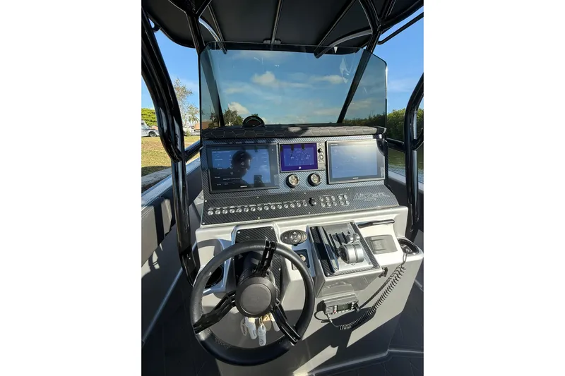  Yacht Photos Pics Control panel of a 2006 Lazer 40 boat with steering wheel and navigation screens.