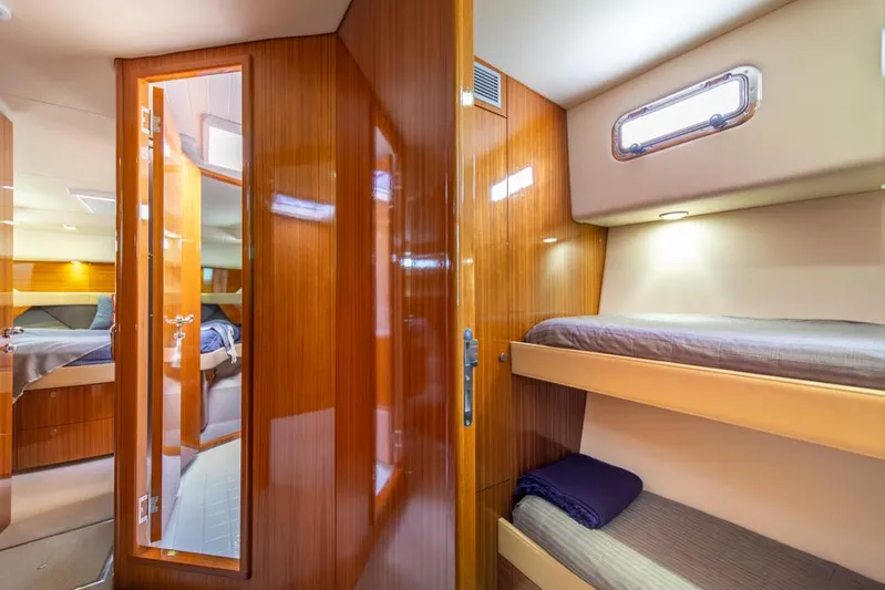 Escape Yacht Photos Pics Interior of 2013 Maritimo M58 yacht with wooden paneling and cozy bunk beds.