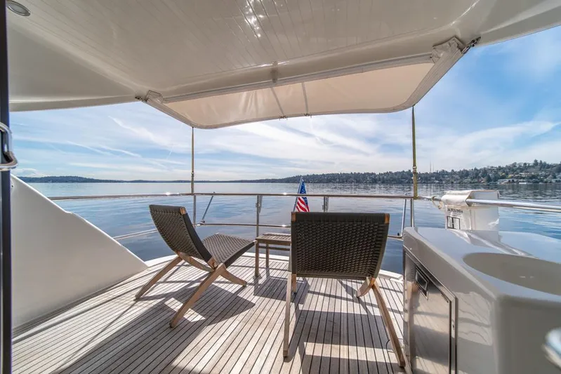 Escape Yacht Photos Pics Luxury deck view on 2013 Maritimo M58 yacht with chairs and scenic water backdrop.