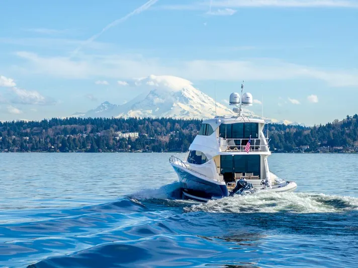 Escape Yacht Photos Pics 2013 Maritimo M58 yacht cruising on a scenic lake with a mountain backdrop.