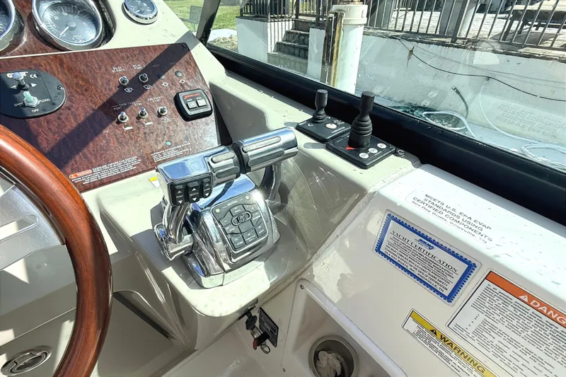 Sweet Melissa Yacht Photos Pics Control panel of a 2013 Sea Ray 370 Venture boat with steering wheel and throttle controls.