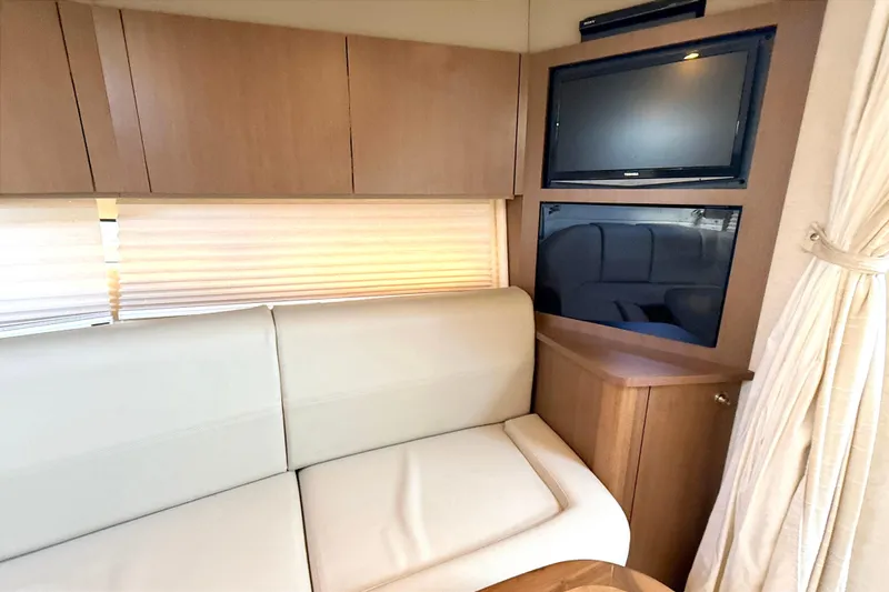 Sweet Melissa Yacht Photos Pics Interior of 2013 Sea Ray 370 Venture with TV, beige sofa, and wooden cabinetry.