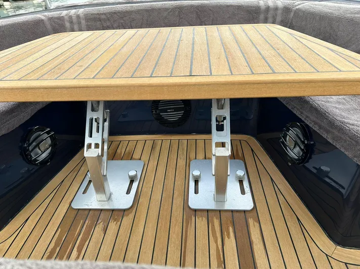 Quoq Yacht Photos Pics Teak table and deck on a 2016 Maori 50 boat, featuring adjustable metal supports.