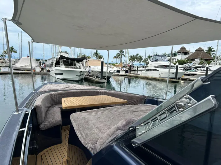 Quoq Yacht Photos Pics Luxury Maori 50 yacht docked at marina, featuring shaded seating and wooden table, 2016 model.