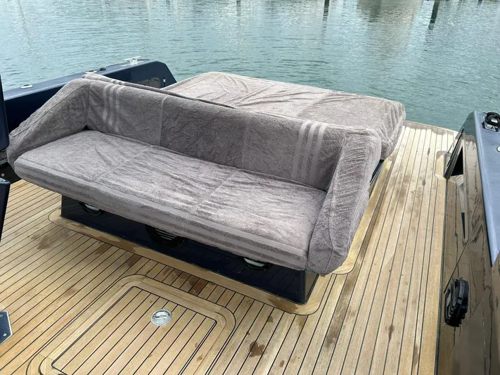 Quoq Yacht Photos Pics Luxury seating on a 2016 Maori 50 yacht with wooden deck, docked by the water.