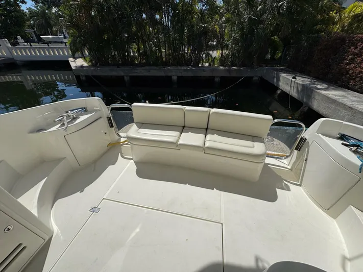 Weekender 3 Yacht Photos Pics 2005 Azimut 42 Fly yacht deck with white seating, docked near lush greenery.