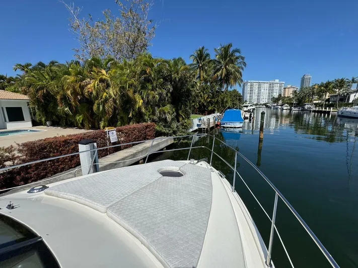 Weekender 3 Yacht Photos Pics 2005 Azimut 42 Fly yacht docked by a tropical waterfront with palm trees.