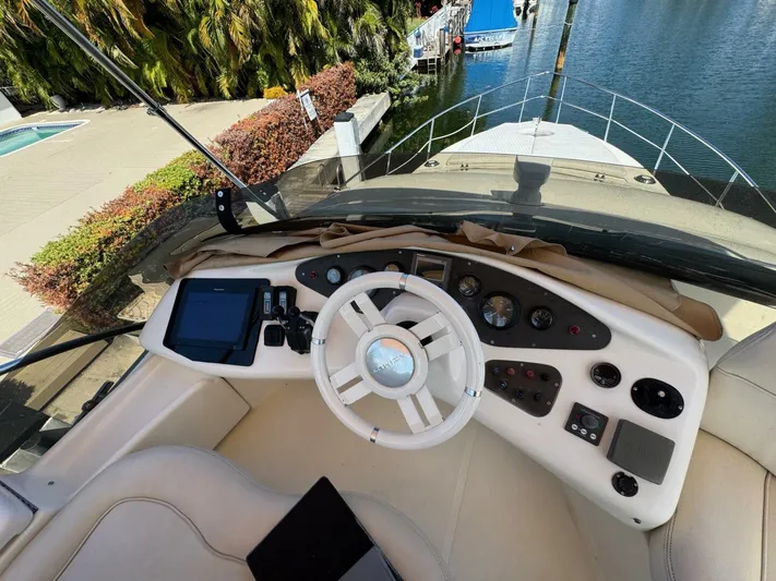 Weekender 3 Yacht Photos Pics 2005 Azimut 42 Fly yacht helm with steering wheel and control panel by the water.