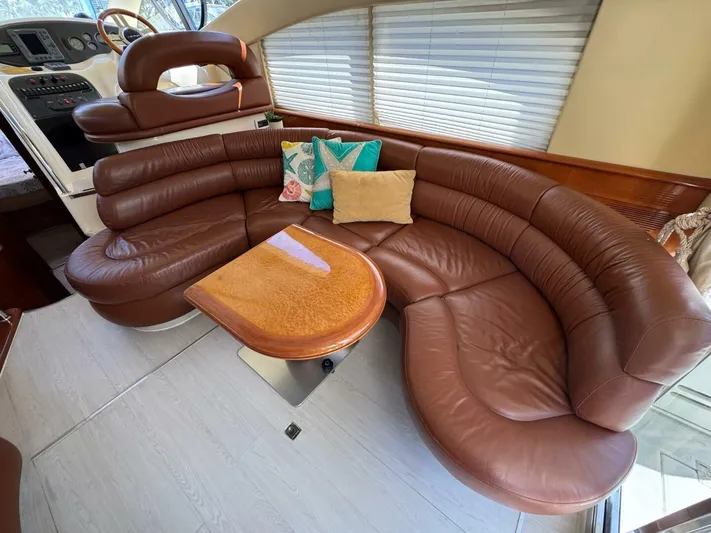Weekender 3 Yacht Photos Pics Luxurious leather seating in 2005 Azimut 42 Fly yacht interior with wooden table.