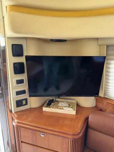 Weekender 3 Yacht Photos Pics Interior of 2005 Azimut 42 Fly yacht with mounted TV and wooden cabinetry.