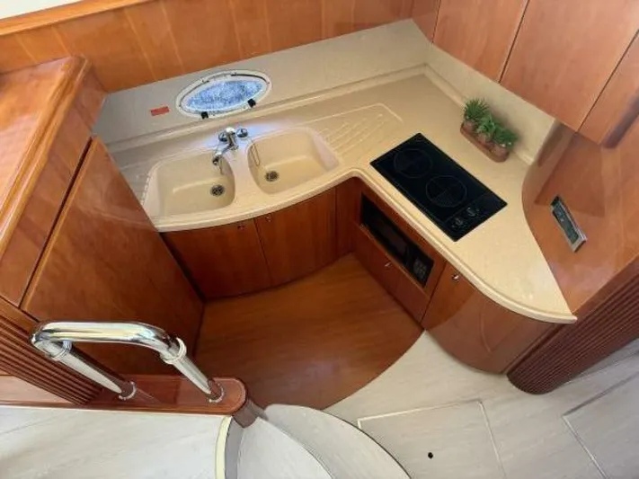 Weekender 3 Yacht Photos Pics 2005 Azimut 42 Fly yacht kitchen with dual sinks, stovetop, and wood cabinetry.