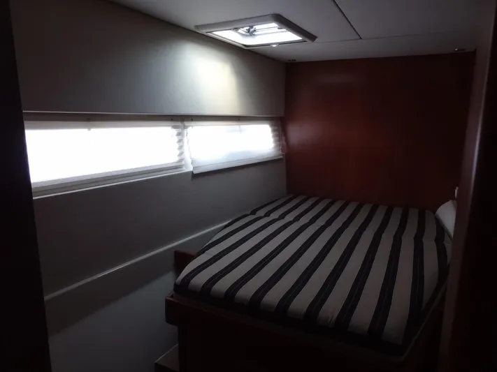 Dalliance Yacht Photos Pics 2014 Leopard 58 yacht interior bedroom with striped bedding and natural light.