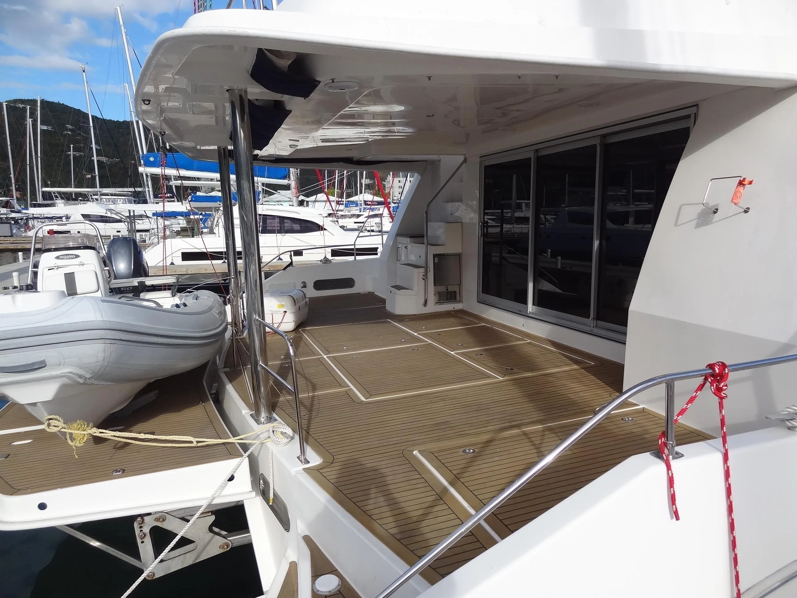 Leopard 58 yacht 2014 model, spacious deck with tender, docked at marina.